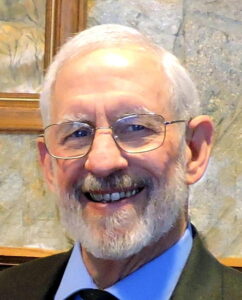 Smiling man with white hair and beard